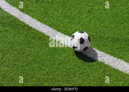 a soccer ball on the green grass on the line in soccer stadium. Stock Photo