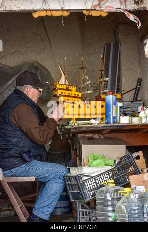 Elderly craftsman building model ship in Bari old town Italy April 6 2026 Stock Photo