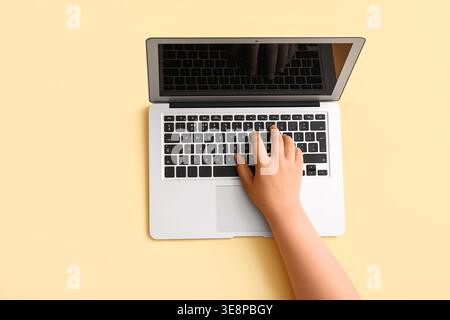 Female hand with modern laptop on beige background Stock Photo