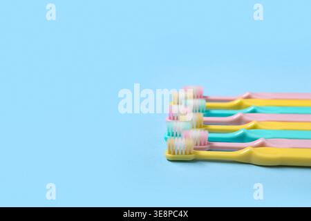 Colorful toothbrushes on blue background. Stock Photo