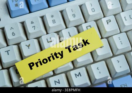 Concept of priority task write on sticky notes isolated on Wooden Table. Stock Photo