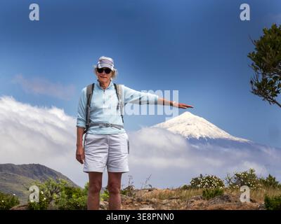 A woman towards a snow capped Mount Teide on Tenerife from Alajero on La Gomera, Canary Islands. Stock Photo