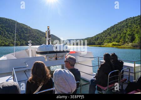 View from a boat which departed from Skradin harbour on its way up the river past forested landscape towards Krka National Park in Croatia. Stock Photo