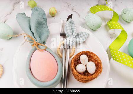 Close-Up of Easter Bunny Napkin on Plate with Nest and Cutlery Stock Photo
