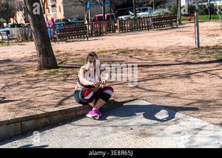 Senior woman squatting in park exercising fitness Stock Photo