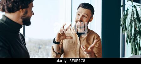 Discussion Takes Place Between Two Men in a Modern Office During Daylight Hours Stock Photo