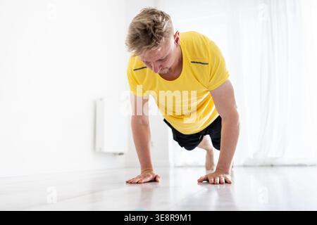 Sporty Young Man Doing Morning Push-Ups As Home Training Stock Photo