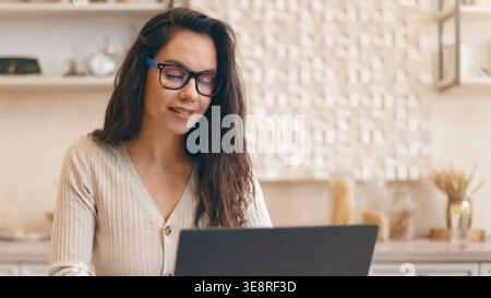 Young Woman Works on Laptop at a Cafe During a Busy Afternoon in a Modern City Environment Stock Photo