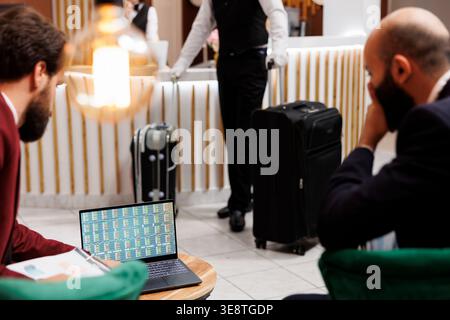 Between meetings and briefing sessions, businessmen discussing about new corporate practises. White collar workers reviewing international partnership notes to create project, work trip. Stock Photo