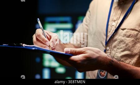 Skillful technician walking in high tech facility supporting AI through high performance computing. IT specialist making sure server hub electronics are in working condition, close up Stock Photo