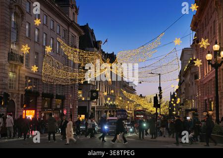Iconic 'Spirit of Christmas' angels hanging above Regent Street St James's at dusk, London, UK.  Christmas lights, LED display, angel, festive xmas Stock Photo