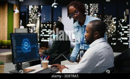 Black colleagues team using AI analytics platform for monthly data reports, reviewing neural networks algorithms and automation for business productivity. IT company representative at work. Stock Photo