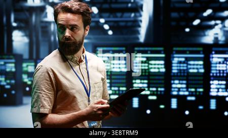 Technician in high tech facility using renewable hydro energy sources to power cryptocurrency farming operations. Specialist working with eco friendly server rigs preventing environmental impact Stock Photo