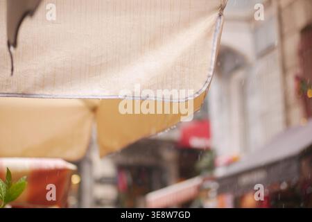 Rain falling on awnings in a busy market street Stock Photo