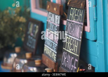 Fresh fruit signs outside a shop in a colorful location Stock Photo
