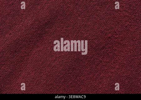 Dark red burgundy knit fabric texture with diagonal weave pattern background close-up Stock Photo