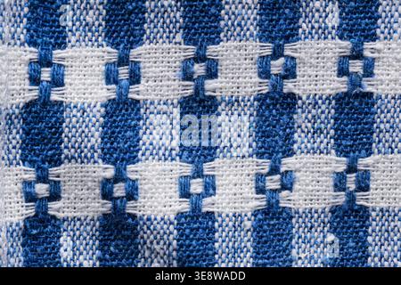 Blue and white woven fabric texture with traditional geometric embroidery pattern close-up Stock Photo