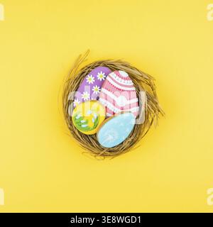 Nest with Easter eggs on a yellow background. Cookies decorated with Easter eggs. Stylish background for Easter Stock Photo