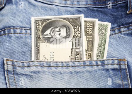 Old Philippine money - peso in the pocket of blue jeans Stock Photo