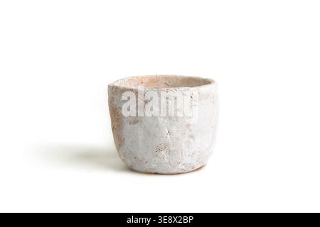Handmade small clay pot isolated on white background. Empty white molded clay vase. Stock Photo