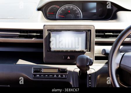 Compact car interior with air vents, hazard button, and multimedia screen. Car Dashboard with Automatic Gear Shift Lever and Infotainment Screen. Stock Photo