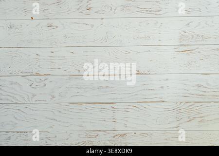 A close-up view of a textured white wooden plank surface, showcasing natural wood grain patterns and a rustic appearance. Stock Photo