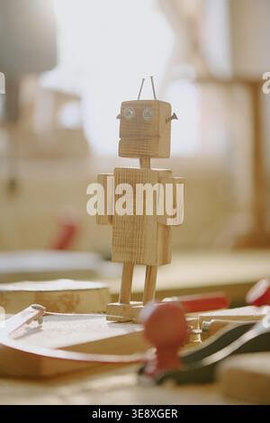Wooden Robot Figure Standing on Workbench for Stem Learning Stock Photo