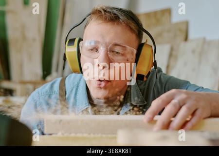 Adult Man Woodworking with Safety Gear in Carpentry Workshop Stock Photo