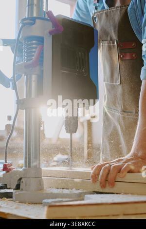 Adult Man Operating Drill Press for Woodworking Production Stock Photo