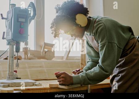 Black Teenager Woodworking in Workshop for Vocational Training Stock Photo