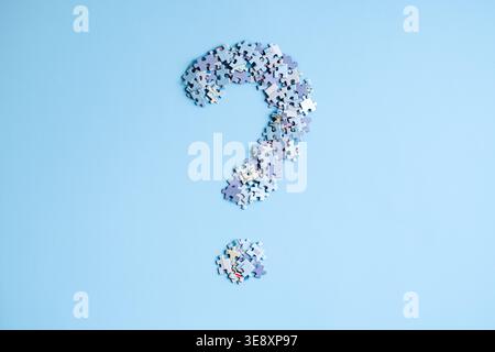 Puzzle pieces arranged in shape of large question mark on light blue background. Global conflict risks, geopolitical instability analysis, world order Stock Photo