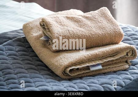 Close up of a stack of towels on a bed in the bedroom Stock Photo