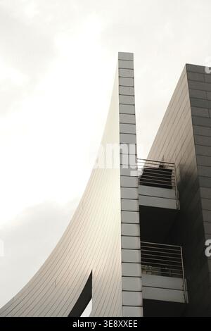 Abstract architectural detail of a modern building in Düsseldorf's Media Harbour, featuring sharp white angles against a pale sky. Stock Photo