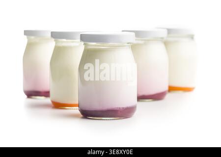 Assorted fruit yogurts layered in small glass jars with white lids, perfect for breakfast, dessert, healthy snacks, product packaging or food photogra Stock Photo