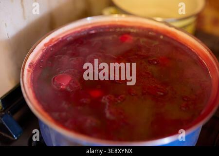 Close up of eggs in a pot being boiled and dyed in water with food coloring Stock Photo
