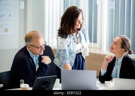 Confident female leader collaborating with diverse professional team in modern office. Real people, Empowered woman Stock Photo
