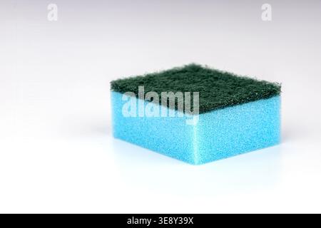 Professional product photograph of a blue foam kitchen sponge featuring a green abrasive scrubber pad on top, isolated on white background for commerc Stock Photo