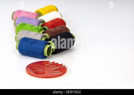Collection of vibrant embroidery thread spools arranged diagonally with neon-trimmed spools in multiple colors including blue, gray, green, pink, purp Stock Photo