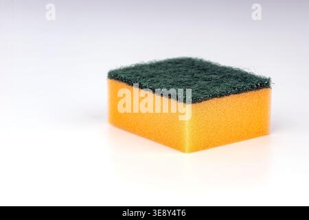 Professional kitchen sponge with soft yellow cellulose foam body and durable green abrasive scrubber pad, ideal for washing dishes, pots, pans, and ki Stock Photo