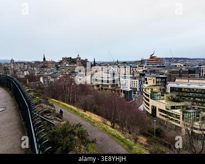 Wide elevated view of Edinburgh skyline featuring Edinburgh Castle, mixed historic and modern buildings and moody winter light. Stock Photo