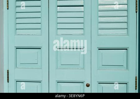 Vintage light blue wooden folding door with horizontal slats and rectangular panels conveying calm and peaceful feeling in classic architectural inter Stock Photo