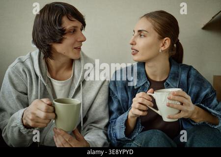 Adult Man and Woman Drinking Coffee and Talking at Home Stock Photo