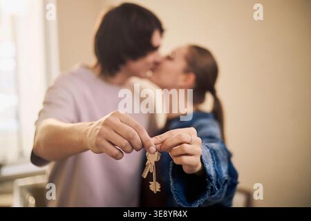 Adult Couple Kissing While Holding House Keys for New Home Purchase Stock Photo