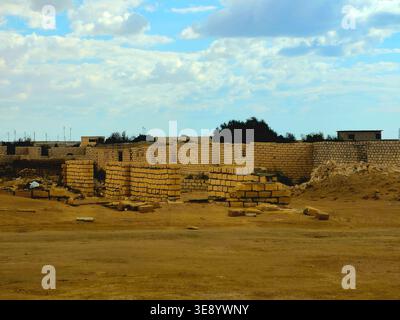 unfinished mud-brick walls of a building situated in a desert environment, the structure is built using compressed earth blocks or bricks made from so Stock Photo
