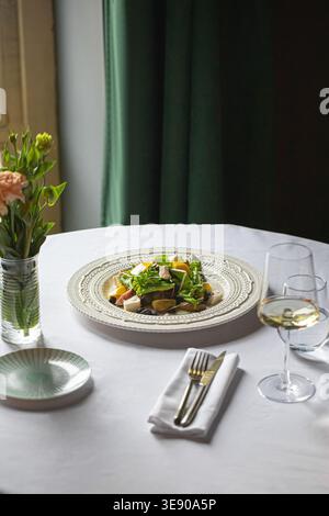Elegant salad with wine on restaurant table Stock Photo