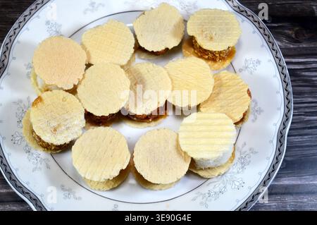 Assorted small, sweet treats, thin, crispy wafers sandwiching patties of sesame, peanuts or coconut, often held together by honey or sugar, popular on Stock Photo