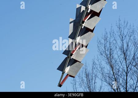Windmill blade detail showing metal panels against a clear blue sky, generating clean power Stock Photo