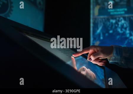 Woman using multimedia touchscreen display of interactive kiosk Stock Photo