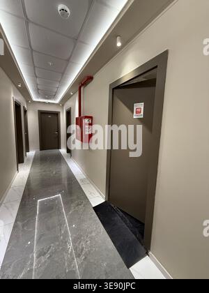 Fire exit door and safety equipment in modern building hallway with marble floor, emergency concept. Mobile photo Stock Photo