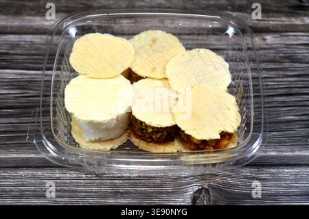 Assorted small, sweet treats, thin, crispy wafers sandwiching patties of sesame, peanuts or coconut, often held together by honey or sugar, popular on Stock Photo